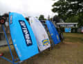 Die Optis stehen in Ständern aufgereiht. Sie sind mit den Logos der über 100 Förderer und Partner des Camps versehen.