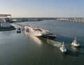 Tugboats pull the half-finished "Orient Express Corinthian" out of the dock.