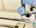 The shaft is pulled, clamped and precisely measured as it rotates.