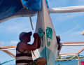 Un artiste local peint des yeux d'Horus sur l'avant du bateau, un symbole de protection très répandu qui remonte à l'Égypte antique.
