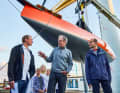 Le chef du chantier naval Jan Brügge, le constructeur Martin Menzner et le professeur Alexander Pfriem, spécialiste des matériaux, devant leur Day-Racer à l'approche durable