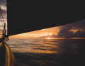 The sun slowly rises from under a cloud as the 11th Hour Racing team sails towards the golden horizon