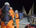 Une image qui ne va pas ensemble : Les pompiers du train de matières dangereuses en combinaison de protection contre les acides sur la passerelle de Fehmarn