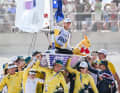 Here, Olympic champion Matt Wearn is carried high up on his Ilca 7 by his team from Down Under