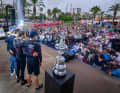Arm in Arm feiern die Segler von American Magic ihren ersten Sieg. Den America's Cup rechts neben ihnen haben sie damit aber nicht gewonnen …