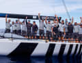 Cheering and waving goodbye: the crew of American Magic Quantum Racing do both at the same time.
