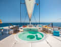Flybridge : pendant que le capitaine s'occupe du réglage des voiles à l'avant du poste de pilotage, les invités profitent de la vue au bar jacuzzi. Il n'y a pas de meilleur endroit pour boire son cocktail - selon la gîte, il est également possible de barboter pendant le voyage.