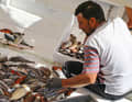 A fisherman sorts his catch at the harbour