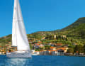 Eine Yacht segelt vor dem Ort Vathy auf der Insel Ithaka