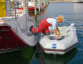 The fore and aft lines hold the dinghy in position. If you don't feel confident enough to take the step, you should climb over the bank