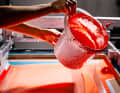 From above, a worker pours paint into the press, which hits the blank