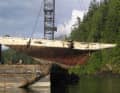 Dopo il successo del recupero dal fondo del Pitt Lake, i resti dello yacht da regata sono appesi alla gru