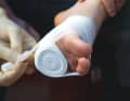 Only unwind a small part of the bandage, the bandage itself serves as a compress. Use the unwound part to press the bandage firmly onto the wound