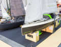 It stands on the Bente stand next to the model made of conventional boat building materials