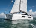 With corners and edges. The hull has pronounced chines just above the waterline. This creates volume in the hulls and narrows the waterline.