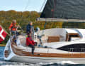 Trim and idleness separate. The rudder and sails are operated from the aft cockpit, where the foresailor does not have much room