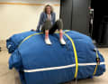 Angela Abshier sits on a sail package weighing several tonnes.