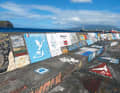Die berühmte Kaimauer mit den Schiffslogos im Hafen von Horta auf Faial ...