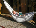 One of the sailors has made himself comfortable in the hammock with a book and a beer