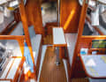 Heavily modified: The saloon is designed for two people. But you can still sleep there: your feet will be under the galley or the navigation table