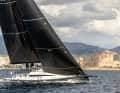 Zwei Hingucker auf einem Bild: die schnittige ClubSwan 43 vor der Basilika von Palma de Mallorca