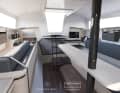 De grandes fenêtres dans la superstructure de la cabine assurent la lumière et l'air sous le pont. La cuisine est installée à l'arrière dans le salon.