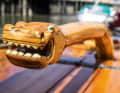 The curved tiller is adorned with an ornately carved dragon's head at the end