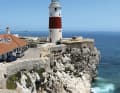 Con venti leggeri, una barca a vela aggira Europa Point a sud di Gibilterra. Il faro è un suggestivo punto di riferimento