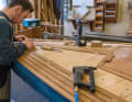 Handwerkskunst noch beinahe wie in alter Zeit: Auf einem Jollenkreuzer verlegt ein Bootsbauer ein neues Teakdeck. Eine zeitraubende Arbeit, bei der Sorgfalt gefragt ist. Leiste um Leiste wird gesägt und auf das Deck geschraubt. Danach werden die Teakfugen vergossen, bevor es ans Schleifen geht