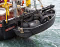 Das Heck wirkt im Vergleich zum bulligen Bug fast zierlich, allein das schwarze Beiboot, in dem Reifen und ebenfalls dunkle Fender kaum auffallen, stellt die Arbeitsbootoptik wieder her