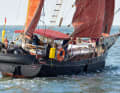 Red sails over a black hull are reminiscent of a workboat. The centreboards provide buoyancy, the internal ballast stability