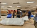 Many hands, good scissors and forklifts are needed to handle the huge cloths.