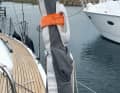 Une poignée (ici une pièce détachée de bateau pneumatique), agrafée à l'étai, peut faciliter la marche à bord. La drisse de gennaker sur la plate-forme ou le bout-dehors de l'étrave aide aussi.