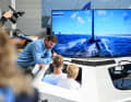 Virtuelles America’s-Cup-Training mit Profis für jedermann: Auf der Interboot darf das Publikum unter Anleitung der deutschen Cup-Youngster Lukas Hesse und Jesse Lindstädt sogar selbst ans Steuer.
