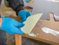 Fine-toothed: To apply the adhesive evenly, a notched trowel with fine teeth must be used. If the tool is too coarse, as is the case when laying tiles, the adhesive layer will be too thick and cannot be pressed on evenly. The coating becomes wavy. In the worst case scenario, the material will break if you try to force it smooth. The AF 270 dispersion adhesive from Ardex that we use comes ready to use from the bucket. However, other adhesives that are available on the market for interior panelling can also be used