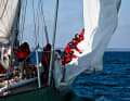 The crew recovering the headsail