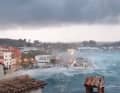 Huge waves crash against the coast.