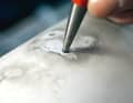 ... can be punched through with a punch and hammer without deforming the top side