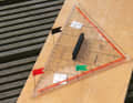 Provisional bearing disc: hand-drawn compass rose on softwood or cork, with pins as a bearing attachment.