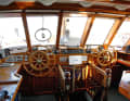 The bridge with two helm stations behind thick safety glass. The companionway leads into the owner's area
