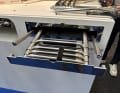 When the side handles are pressed down, the entire ladder folds up. Everything can then be pushed into the storage space.