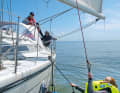 If a rescue via the stern is too dangerous, try to climb back on board amidships, for example with the help of a rescue ladder. If the casualty is exhausted or the sea is too rough, he must be winched up. To do this, attach the spifall to the lift strap on the waistcoat
