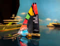 The Malizia Seaexplorer model sails in front of typical Monaco yachts.