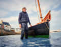 Exiled Brit Roger Barnes in front of his Ilur "Avel Dro" in its home port of Douarnenez