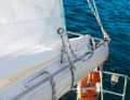 4. pull the reefing line through: Tighten the reefing line until the leech is on the boom. In the photo, the attachment of the reefing line to the boom has too much play, ideally it should be closer to the profile. Make sure that the reefed cloth does not get caught between the boom and the sail. Tighten the sheet again