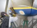 Per Sandstrahl werden Antifouling, Gelcoat und das beschädigte Laminat abgetragen