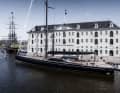 „Nilaya“ neben dem Amsterdamer Schifffahrtsmuseum, achteraus von der Replik eines Ostindienfahrers