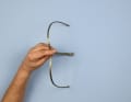 If you are right-handed, grip the shackle with your left hand and place your index finger on the fork