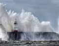 Waves crash against the harbour wall of the Newhaven lighthouse in Newhaven, Great Britain