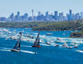 The 100-foot maxis "Master Lock Comanche" and "LawConnect" are flanked by an armada of spectators.
